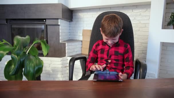 小男孩在家里玩数码平板电脑的时候笑了，小孩在玩平板电脑的时候笑了 — 图库视频影像