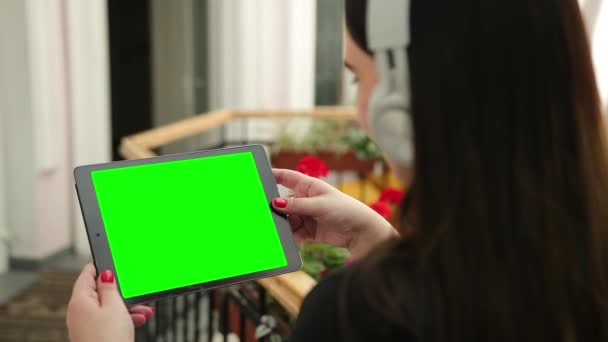 Mockup mulheres mãos segurando tablet pc com fones de ouvido branco tela em branco — Vídeo de Stock