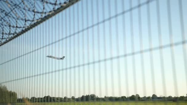 비행기가 철조망을 넘어 날아가고 있다. Wire fencing 메시 라인 철 체인 링크 — 비디오