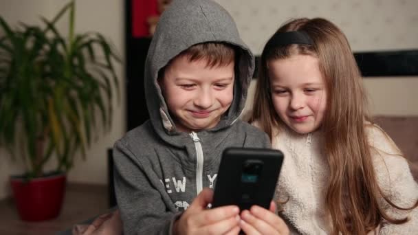 Enfants étonnants regardant le téléphone intelligent, jeunes smartphones heureux ensemble — Video