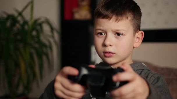 De man speelt op de console, kleine jongen speelt videospel zittend op de bank — Stockvideo