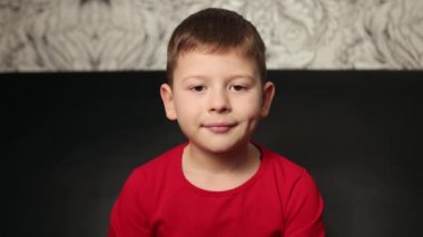 Önüne bakan sevimli, mutlu bir çocuk. Yakışıklı bir delikanlının yakın plan portresi.