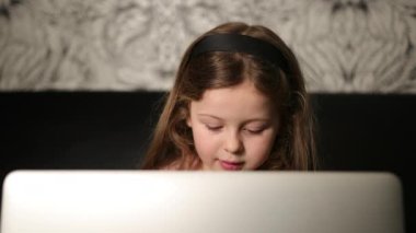 Laptop tutan genç bir kız portresi. Delikanlı evde bilgisayar kullanıyor. 6 yaşında.