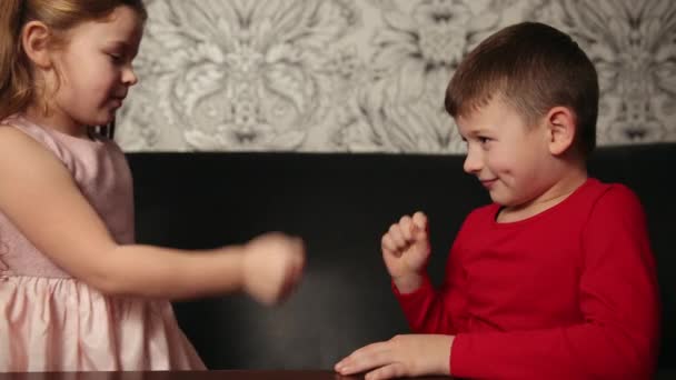 Niño y niña juegan a las tijeras de papel de roca. Niños felices, niños jugando juego — Vídeos de Stock