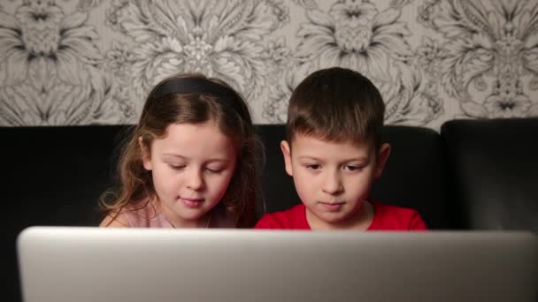 自宅でラップトップコンピュータを探している焦点を当てた子供たち。ノートを使って勉強する少年 — ストック動画