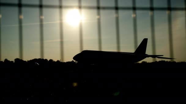 Σιλουέτα ενός αεροπλάνου στο ηλιοβασίλεμα προσέγγιση στο αεροδρόμιο ένα όμορφο ουρανό — Αρχείο Βίντεο