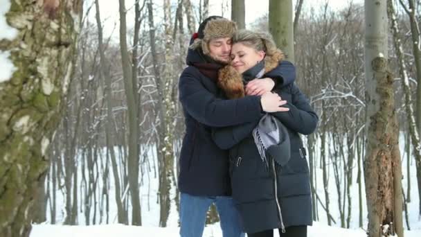 Mann umarmt Frau aus nächster Nähe im verschneiten Wald. Stimmungsvoller sinnlicher Moment. — Stockvideo