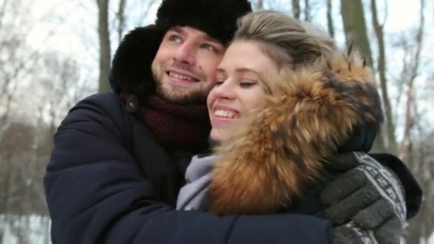 Hombre abrazando a mujer de cerca en el bosque cubierto de nieve. Momento sensual atmosférico. — Vídeo de stock