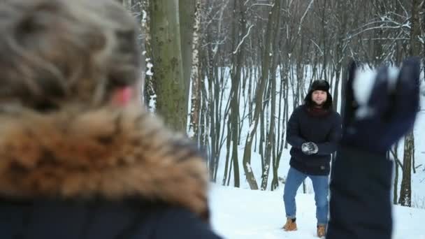 ペアは雪合戦だ。冬の楽しみ。男は友人の顔に雪を投げ — ストック動画