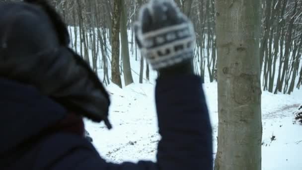 L'uomo lancia palla di neve contro un tronco d'albero. Colpisci il bersaglio. Inverno nevoso gelido giorno — Video Stock