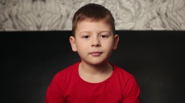 Önüne bakan sevimli, mutlu bir çocuk. Yakışıklı bir delikanlının yakın plan portresi.