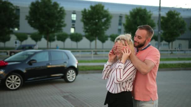 Joven marido, el hombre está dando regalo de coche esposa, novia. Mujer extremadamente feliz — Vídeos de Stock