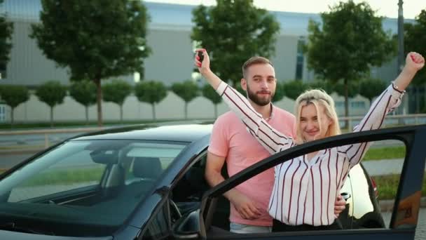Unga par jublar över bilen, sträcker upp händerna. Resor, smekmånad utomlands. — Stockvideo