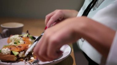 Bluz giyen güzel bir kadının portresi salata yerken akşam yemeğinin tadını çıkarıyor.