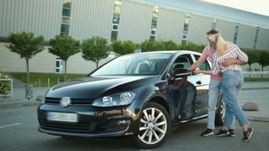 Elektrikli araç al. Satış elemanı bir çift arabaya bakıyor. Mutlu genç