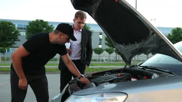 Muž zkoumá motor auta před nákupem od prodejce. Zvednutý čepec. Vozidlo — Stock video