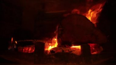 Şöminede odun yanıyor. Ateşin sıcak dilleri sıcak yanar. Sıcak, romantik.