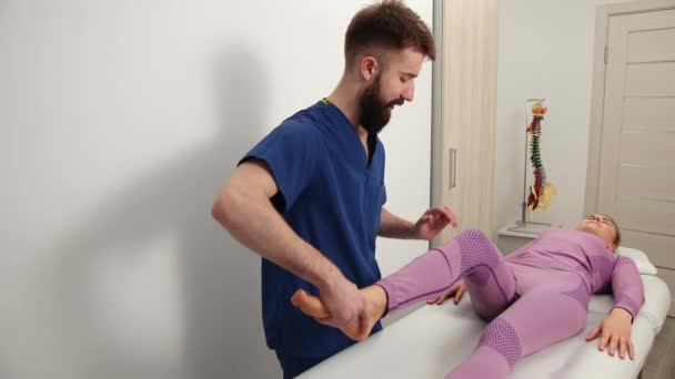 セラピストは女性の足、膝の治療を行う。カイロプラクティック,骨粗しょう症 — ストック動画