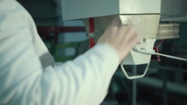 Eine Arbeiterin verpackt Zucker mit einer Maschine auf einem Förderband der Zuckerrübenanlage. — Stockvideo