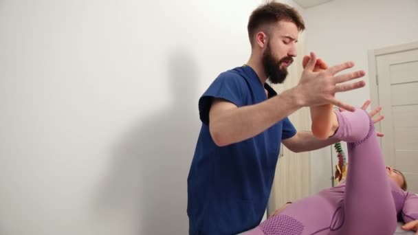 Terapeut léčí ženskou nohu, koleno. Chiropraktická, osteopatie — Stock video