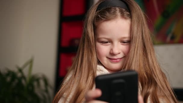 Junges Mädchen schaut sich ein Video auf ihrem Handy an, sie schaut lustige Videos — Stockvideo