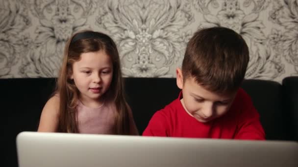 Miúdos focados a olhar para o computador portátil em casa. Usando notebook, menina menino estudando — Vídeo de Stock