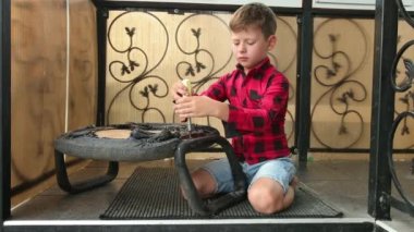 Çocuk sandalyeyi tornavidayla tamir ediyor vidaları söküyor, vidayı sıkıyor, cıvata takıyor. Efendim!