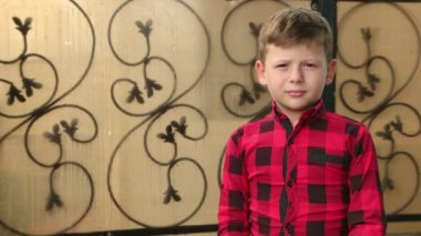 Küçük çocuk elinde bir tornavida tutuyor, kameraya bakıyor ve çeviriyor..