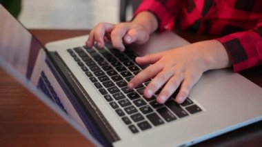 Çocuk anahtar defterini kapatıyor. Online eğitim. Çocuklar dizüstü bilgisayarın anahtarlarını verir