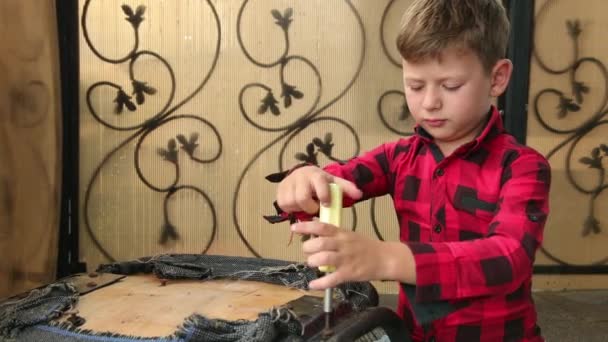 Dreng reparationer stol med en skruetrækker skruer strammer skruen, bolt. Føreren – Stock-video
