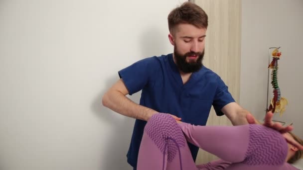 Fyzioterapeutická rehabilitace, manipulace s kolenem pacienta. Fyzioterapeut — Stock video