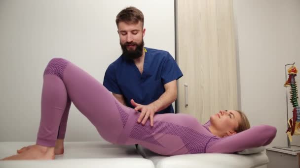 Physiotherapeutin bei der Mobilisierung der Wirbelsäule, das Becken von Mädchen wird manipuliert — Stockvideo