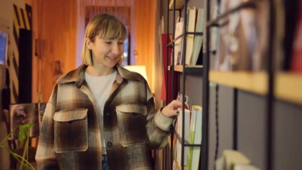Kvinna läser bok i biblioteket. Porträtt college dam vänder sidor. Kvinnlig bok — Stockvideo