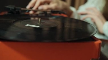 El, evdeki eski plakçalar vinil diskleri ayarlıyor. Vinil ses oynatıcı