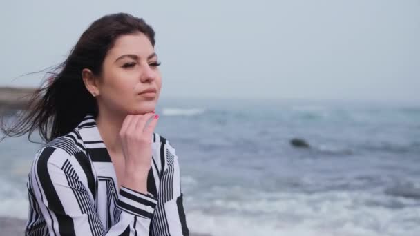 Femme rêveuse une brune mignonne avec de longs cheveux noirs vagues de mer. Portrait — Video