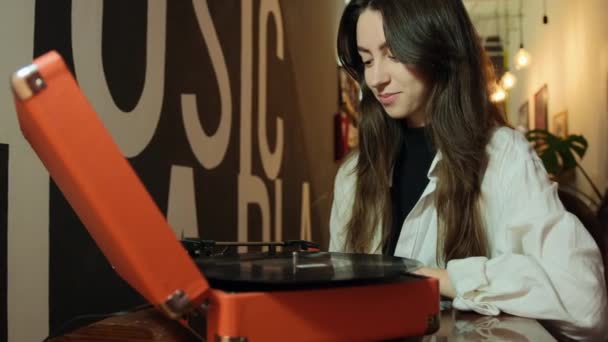 Fiatal nő régi lemezjátszóval és bakelitlemezekkel otthon. Női vinil audio — Stock videók