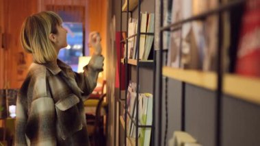 Üniversite kütüphanesinde açık kitap okuyan zeki bir öğrencinin portresi. Kadın.