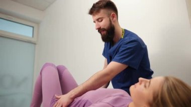 Fizyoterapist omurga hareketliliği, kızın leğen kemiği manipüle ediliyor.