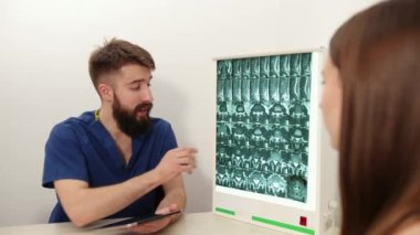 Kadın hasta klinikte erkek terapistle konuşuyor. Fizyoterapist hastalandı.