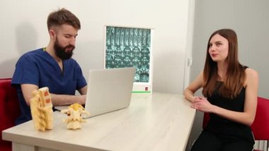 Kadın hasta klinikte erkek terapistle konuşuyor. Fizyoterapist hastalandı.