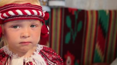 Eski Ukrayna vyshyvanka kostümlü küçük bir kızın portresi, gülümsüyor.