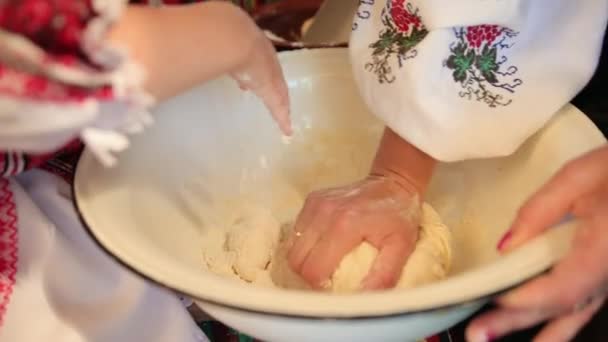 Produits de boulangerie faits à la main. Mère et petite fille pétrissent la pâte pour cuire le pain — Video