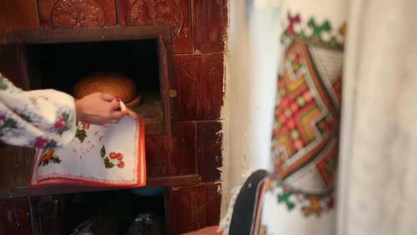 Giovane donna in un costume tradizionale ucraino vyshyvanka mette pasta di pane crudo — Video Stock