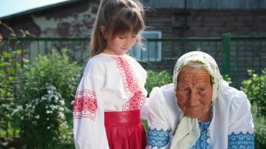Yaşlı bir büyükanne sokakta oturuyor ve bir kitap okuyor. Kızım dinle.