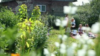 Yaşlı bir büyükanne sokakta oturuyor ve bir kitap okuyor. Kızlar dinleyin.