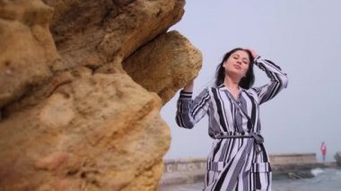 Kayaya yaslandı ve başını eğdi. Hayalci kadın, tatlı bir esmer kadın.