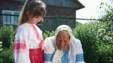 Yaşlı bir büyükanne sokakta oturuyor ve bir kitap okuyor. Kızım dinle.