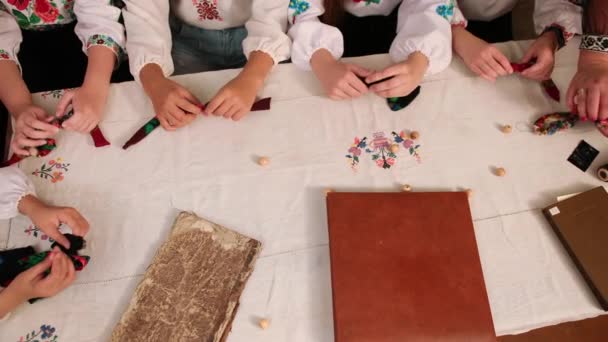 Eine Gruppe von Mädchen fertigt Schmuck aus Schals, Handarbeit, Handarbeit Kreis. — Stockvideo