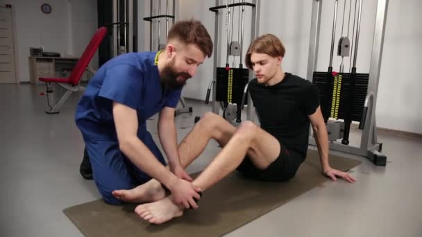 Athlète patient masculin dans le concept de physiothérapie sportive clinique. Thérapeute — Video