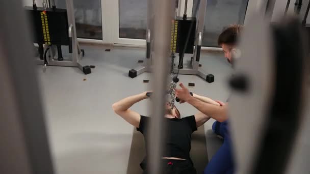 Rehabilitasyon konsepti. Fizyoterapist altında egzersiz yapan genç bir adam. — Stok video